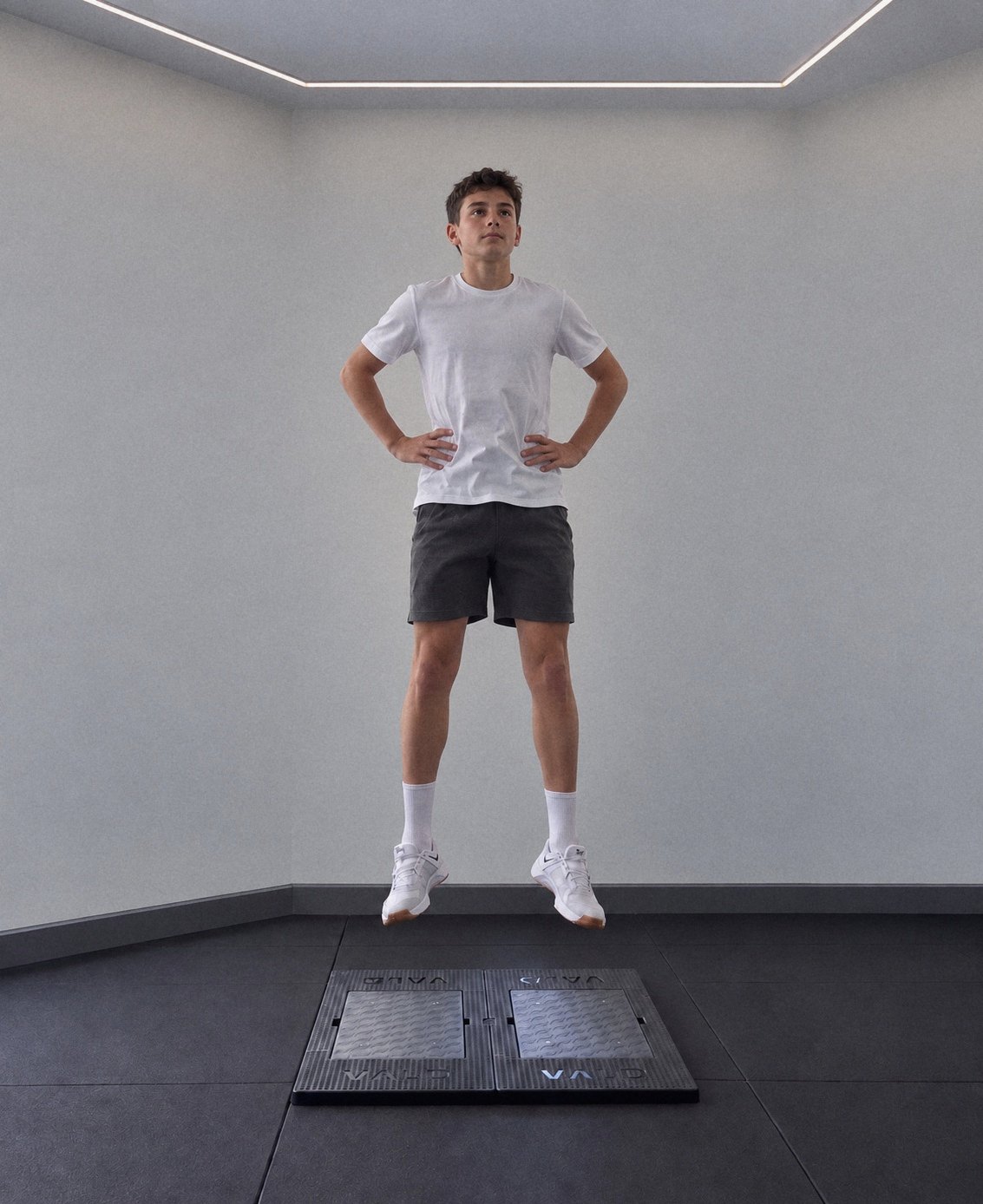A youth athlete in mid-air above a pair of VALD ForceDecks force plates during a jump test