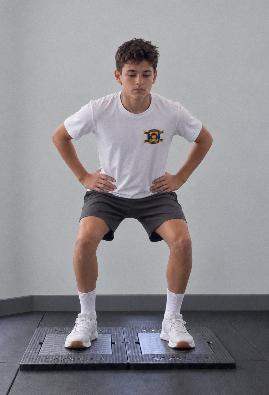 A youth athlete in a squat on a pair of VALD ForceDecks force plates before a jump